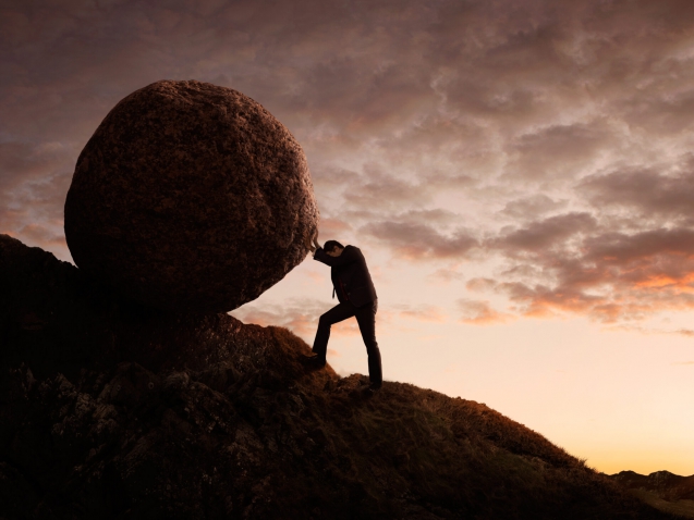 Business concept, Young businessman pushing large stone uphill with copy space