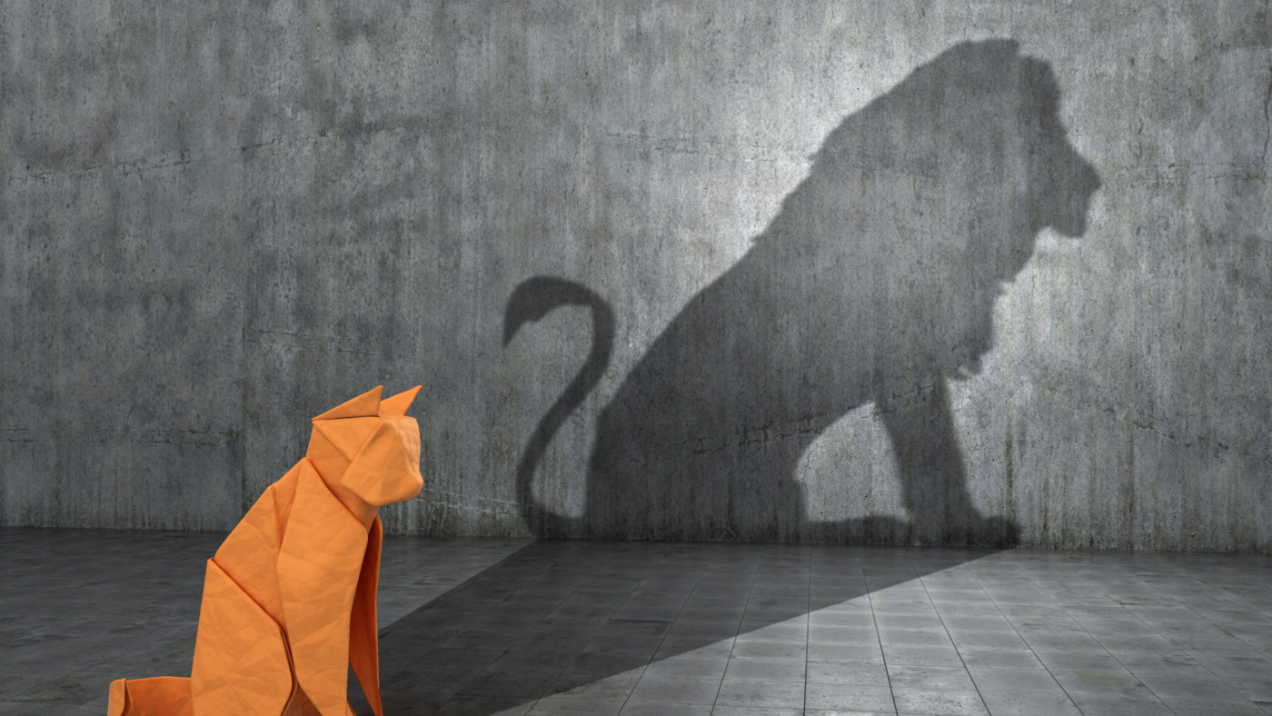 Concept of hidden potential. A paper figure of a cat that fills the shadow of a lion. 3D illustration