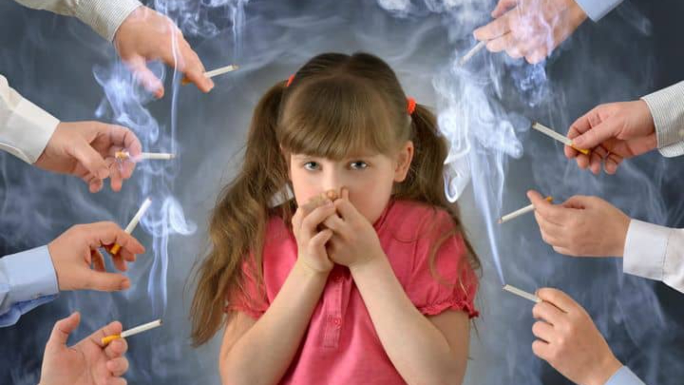 Smoking in front of the child kid .A little girl covers her nose from tobacco smoke.Conceptual photography.
