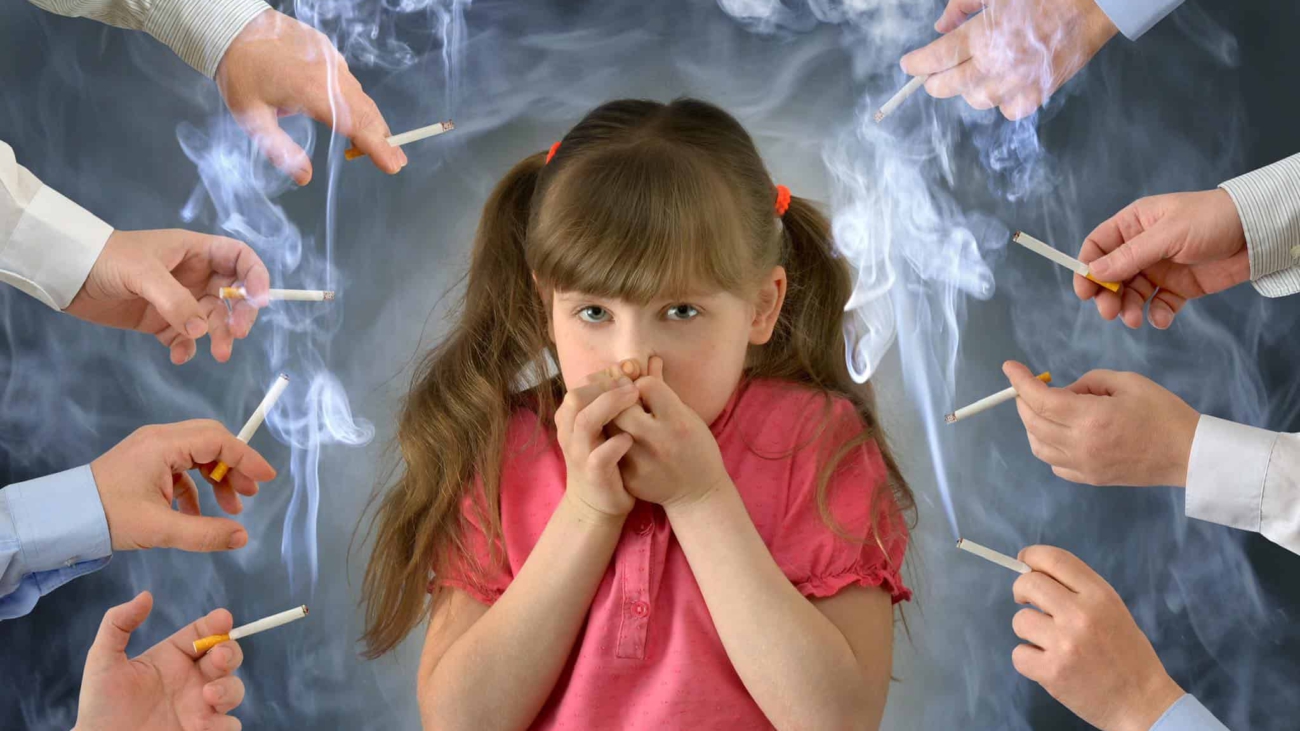 Smoking in front of the child kid .A little girl covers her nose from tobacco smoke.Conceptual photography.